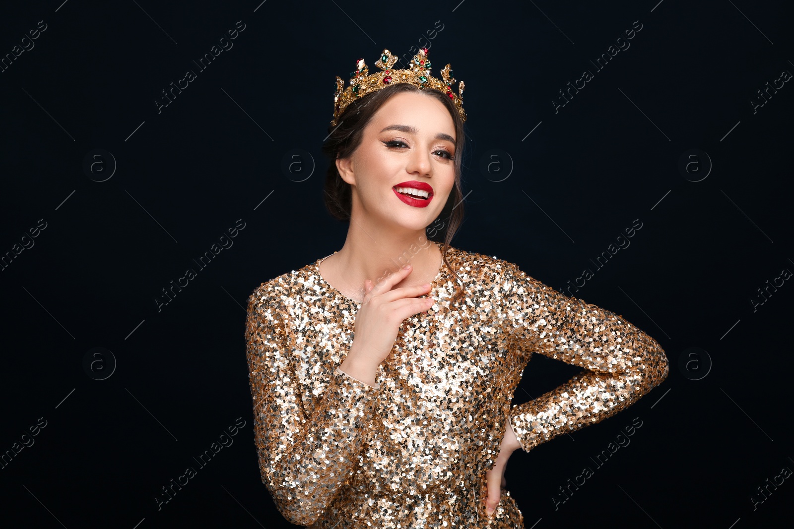 Photo of Beautiful young woman wearing luxurious crown on black background