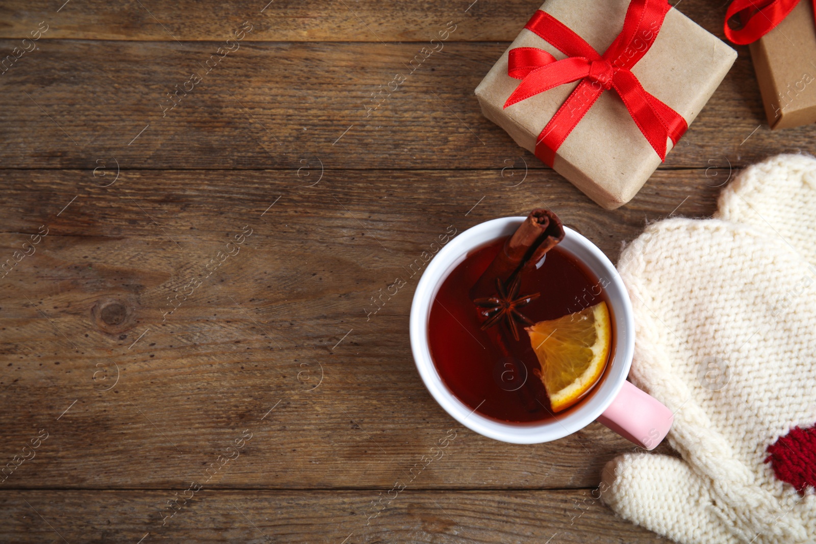 Photo of Flat lay composition with cup of hot mulled wine on wooden table, space for text. Winter drink