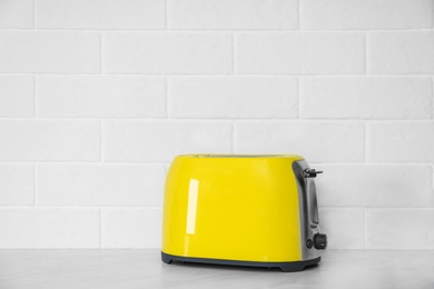 Photo of Modern yellow toaster on countertop in kitchen. Space for text