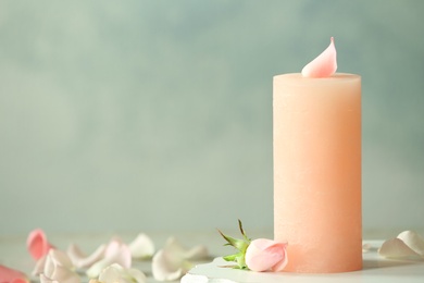 Photo of Candle with floral decor against color background