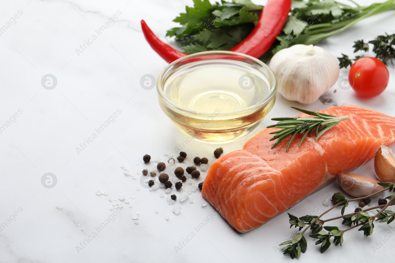 Photo of Fresh salmon and ingredients for marinade on white marble table. Space for text