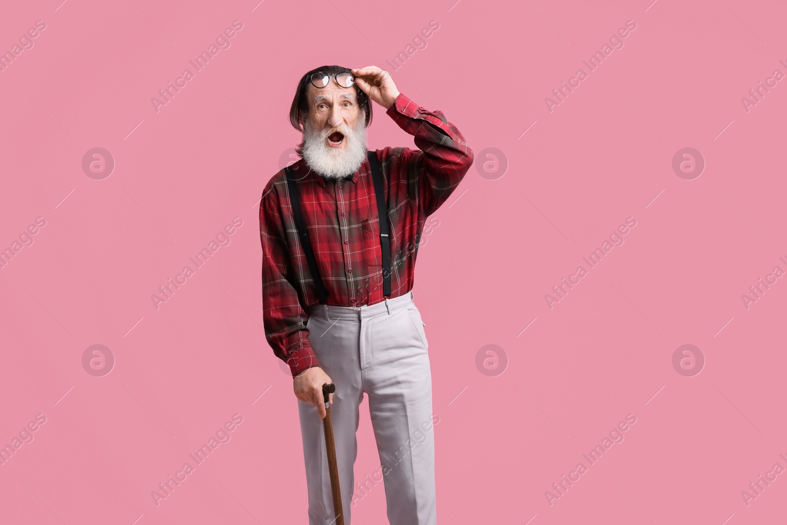 Photo of Surprised senior man with walking cane on pink background