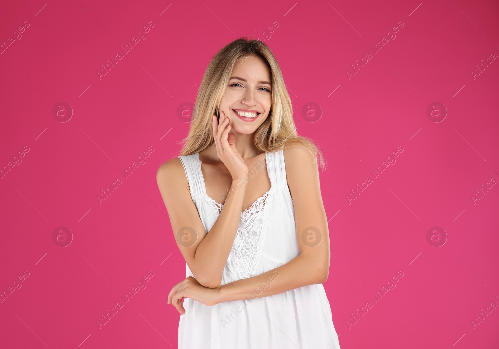 Photo of Young woman wearing stylish white dress on pink background