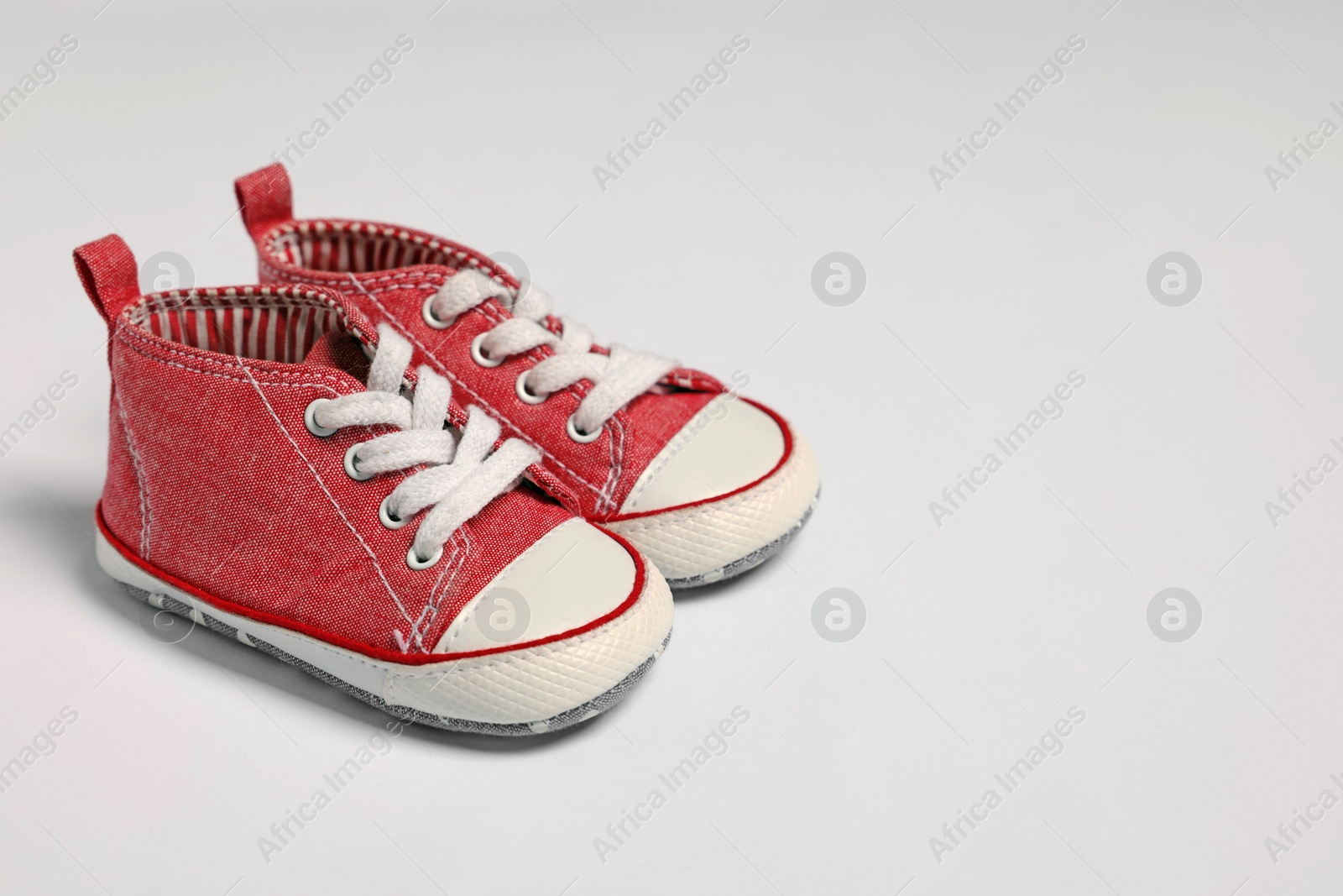 Photo of Cute baby shoes on white background, space for text