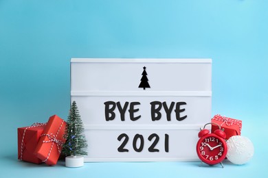 Image of Lightbox with phrase Bye Bye 2021 and Christmas decorations on light blue background