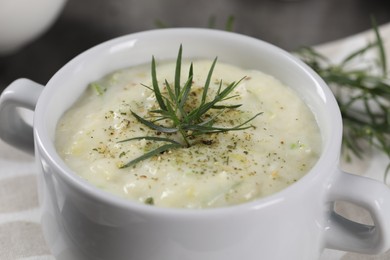 Photo of Delicious cream soup with tarragon, spices and potato in bowl, closeup