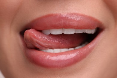 Photo of Woman with beautiful lips licking her teeth, closeup
