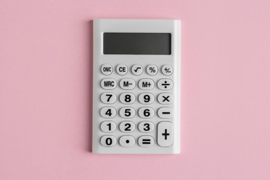 White calculator on pink background, top view