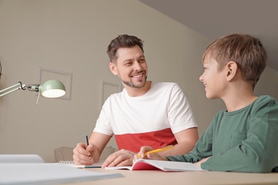 Dad helping his son with school assignment at home