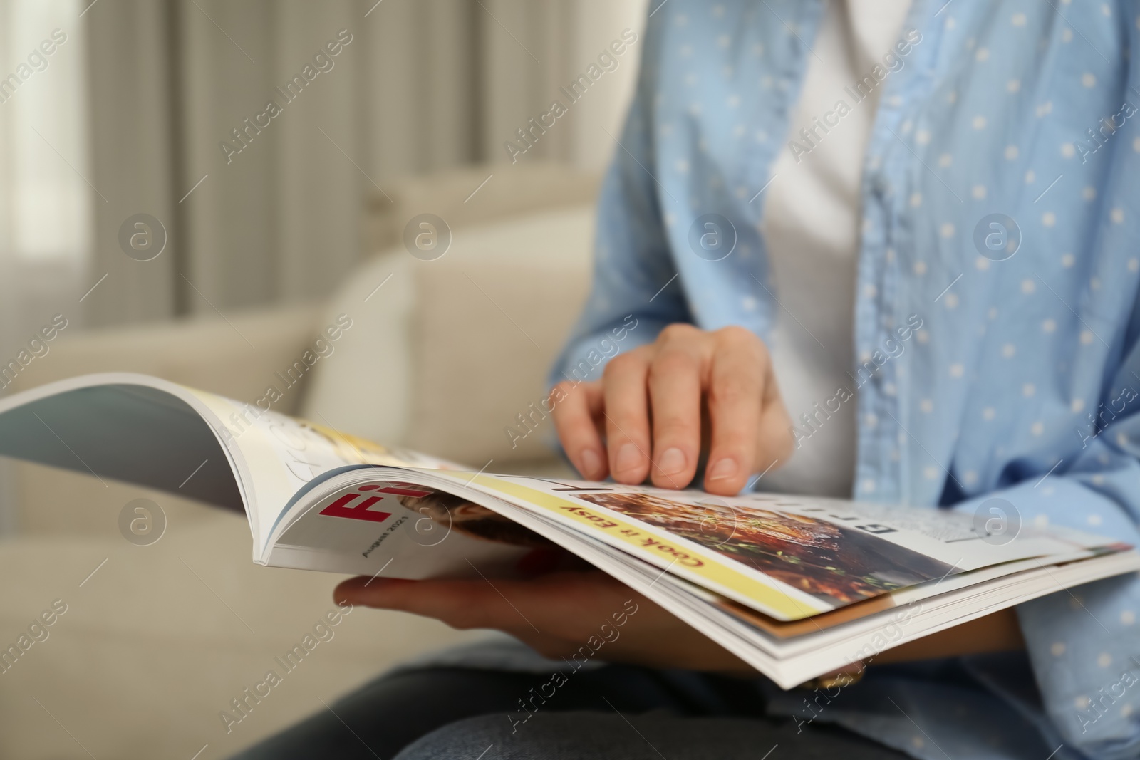 Photo of Woman reading modern magazine at home, closeup