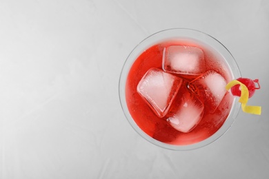 Photo of Glass of tasty refreshing cocktail on grey background, top view. Space for text