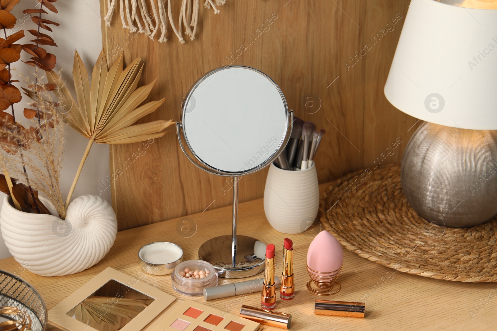 Photo of Dressing table with mirror and makeup products in room