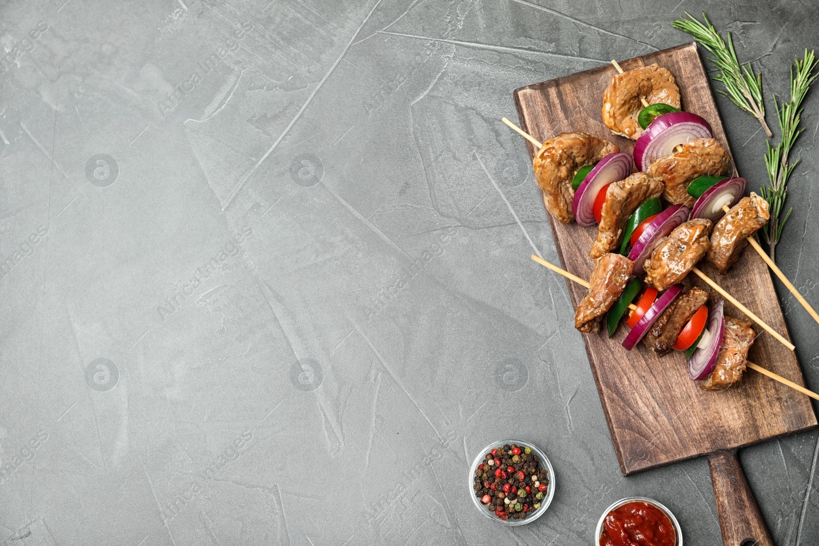 Photo of Roasted meat served with vegetables and sauce on grey background, flat lay. Space for text