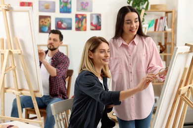 Photo of Artist and her students having painting class in studio. Creative hobby