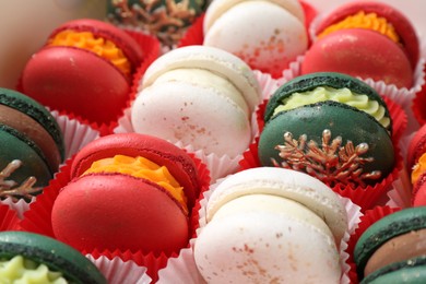 Photo of Different beautifully decorated Christmas macarons on table, closeup