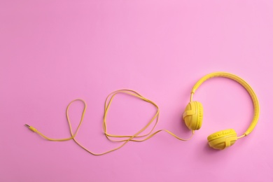 Photo of Stylish headphones on color background, top view. Space for text