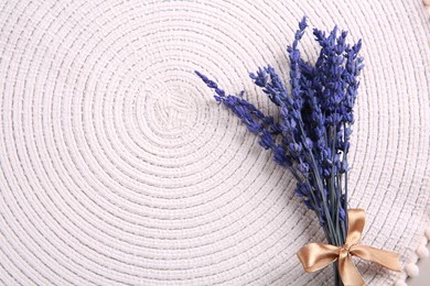 Photo of Bouquet of beautiful preserved lavender flowers on white cotton place mat, top view. Space for text