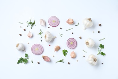 Photo of Fresh garlic, onion rings and spices on white table, flat lay