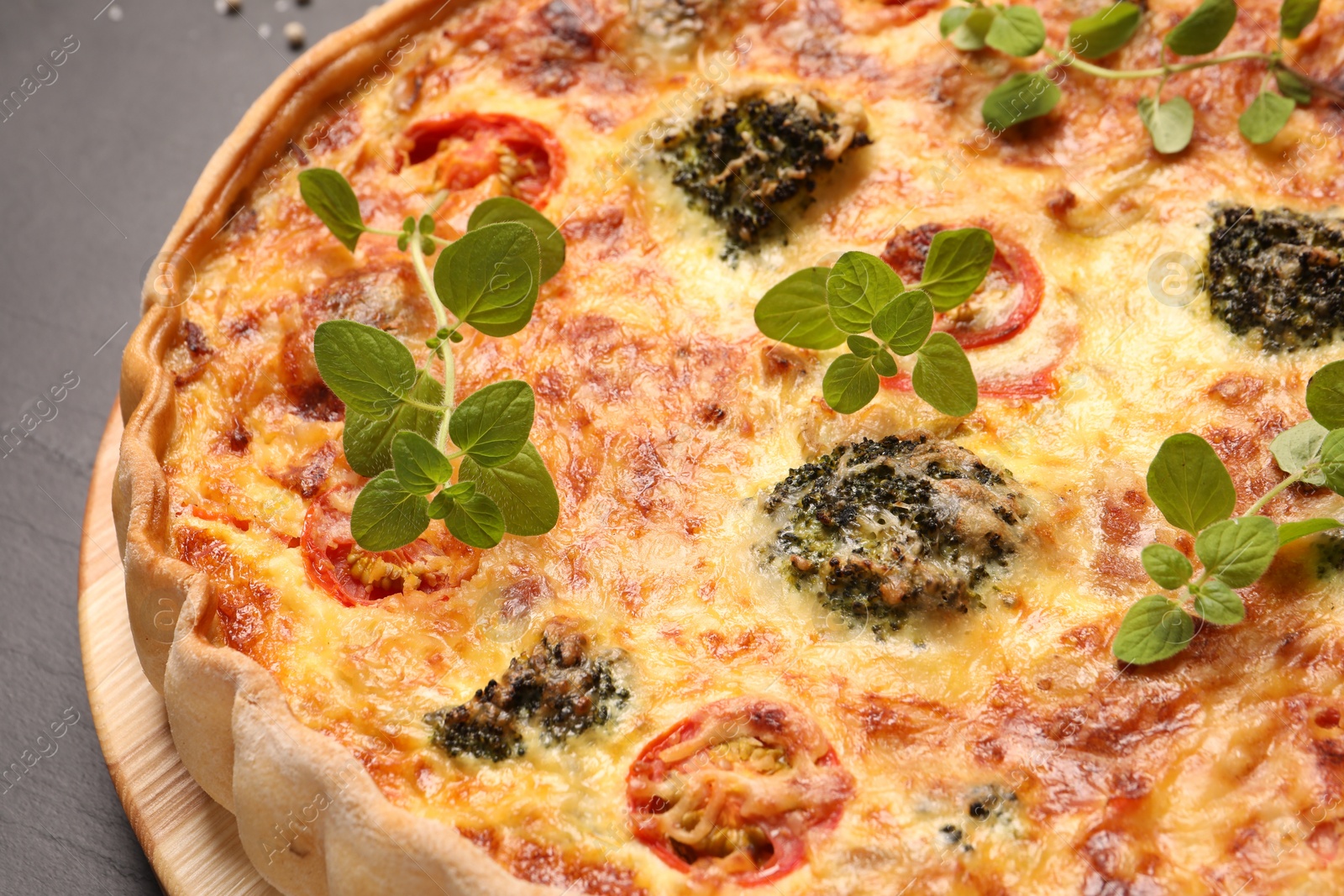 Photo of Delicious homemade vegetable quiche on dark table, closeup