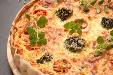 Delicious homemade vegetable quiche on dark table, closeup