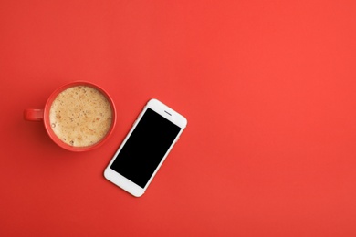 Photo of Cup of coffee and phone on red background, top view. Space for text