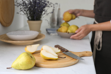 Photo of Fresh cut and whole pear on white countertop in kitchen