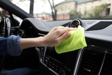 Photo of Woman wiping her modern car with rag, closeup