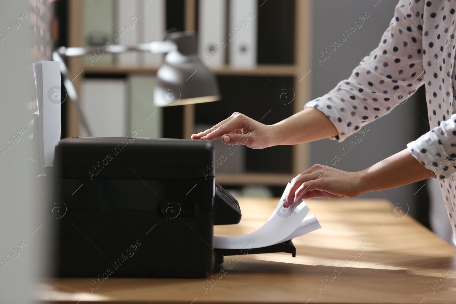 Photo of Employee using modern printer in office, closeup