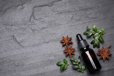 Flat lay composition with anise essential oil on grey background, space for text