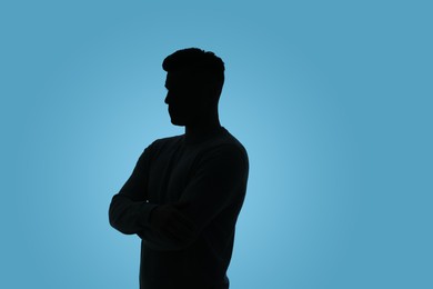 Photo of Silhouette of anonymous man on light blue background