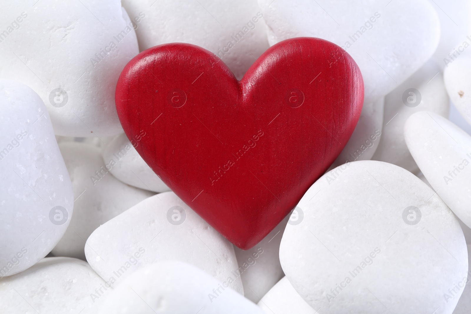 Photo of Decorative heart on white pebble stones, above view