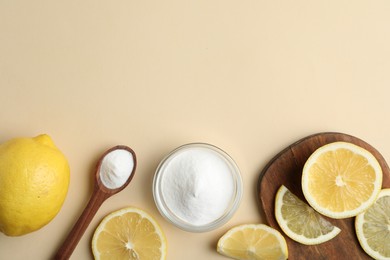 Photo of Baking soda and lemons on beige background, flat lay. Space for text