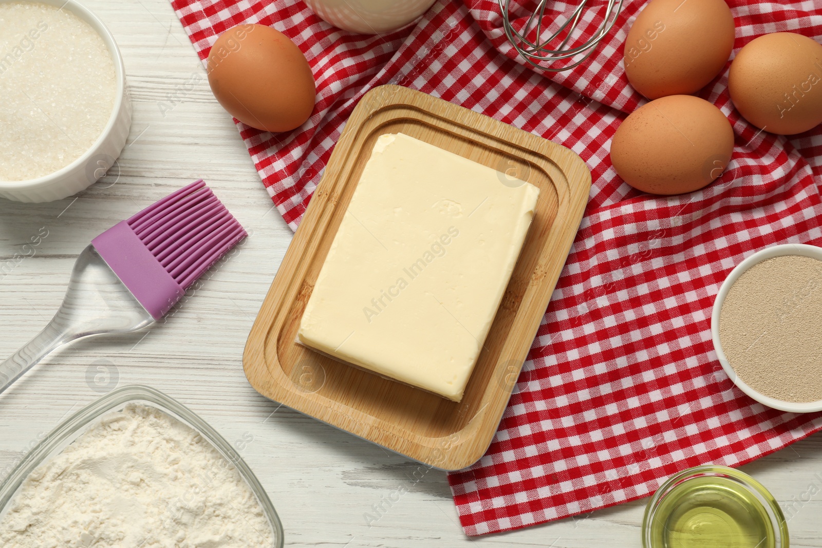 Photo of Flat lay composition with fresh butter and other products on light wooden table