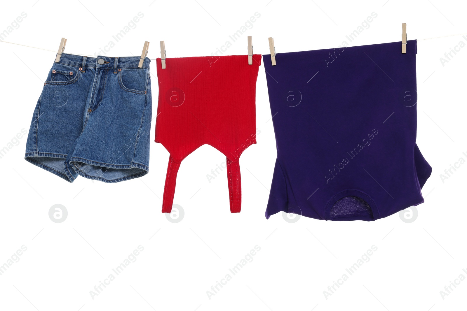 Photo of Different clothes drying on laundry line against white background