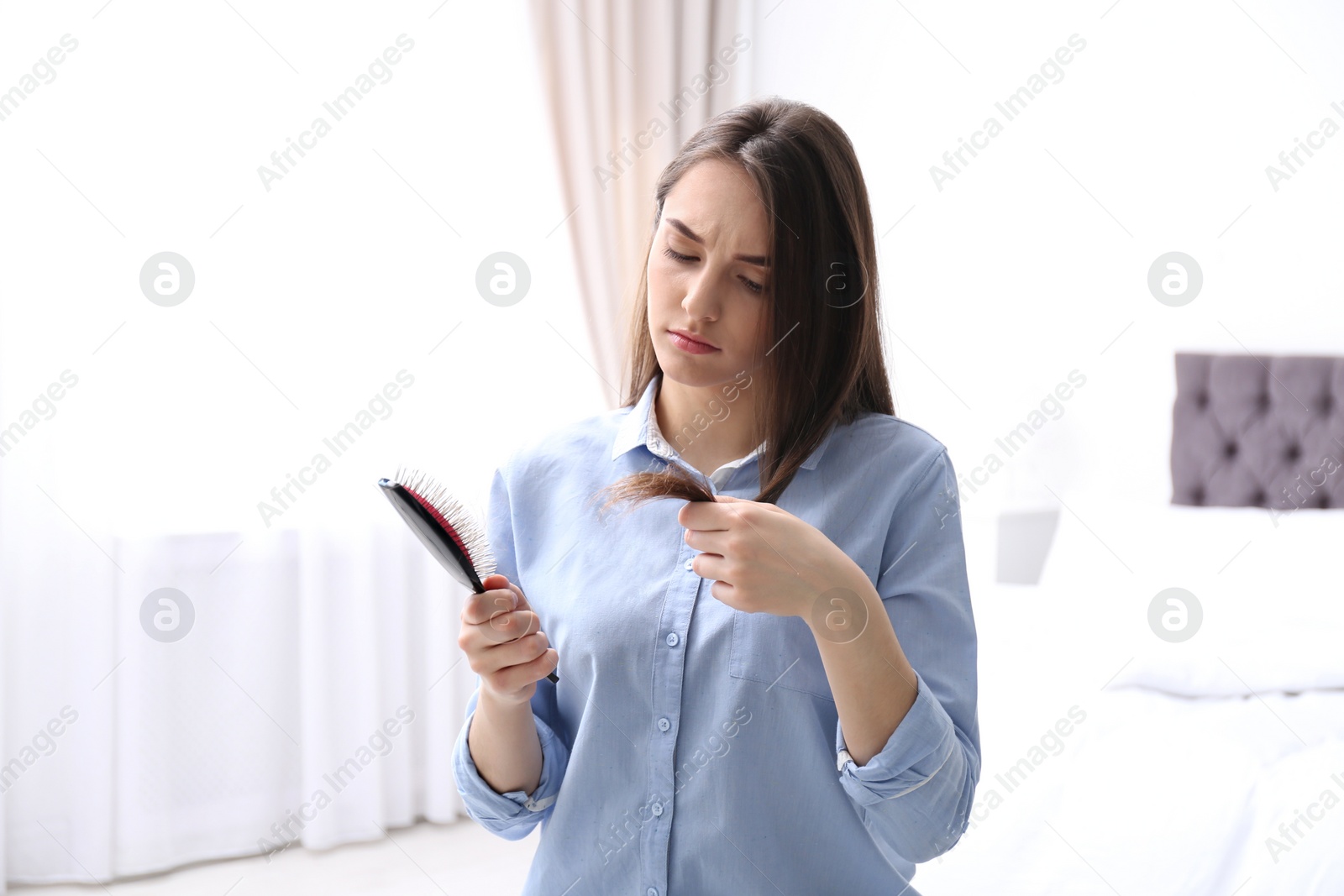 Photo of Young woman with brush indoors. Hair loss problem