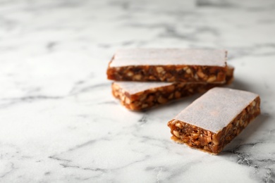 Photo of Tasty protein bars on marble table. Space for text