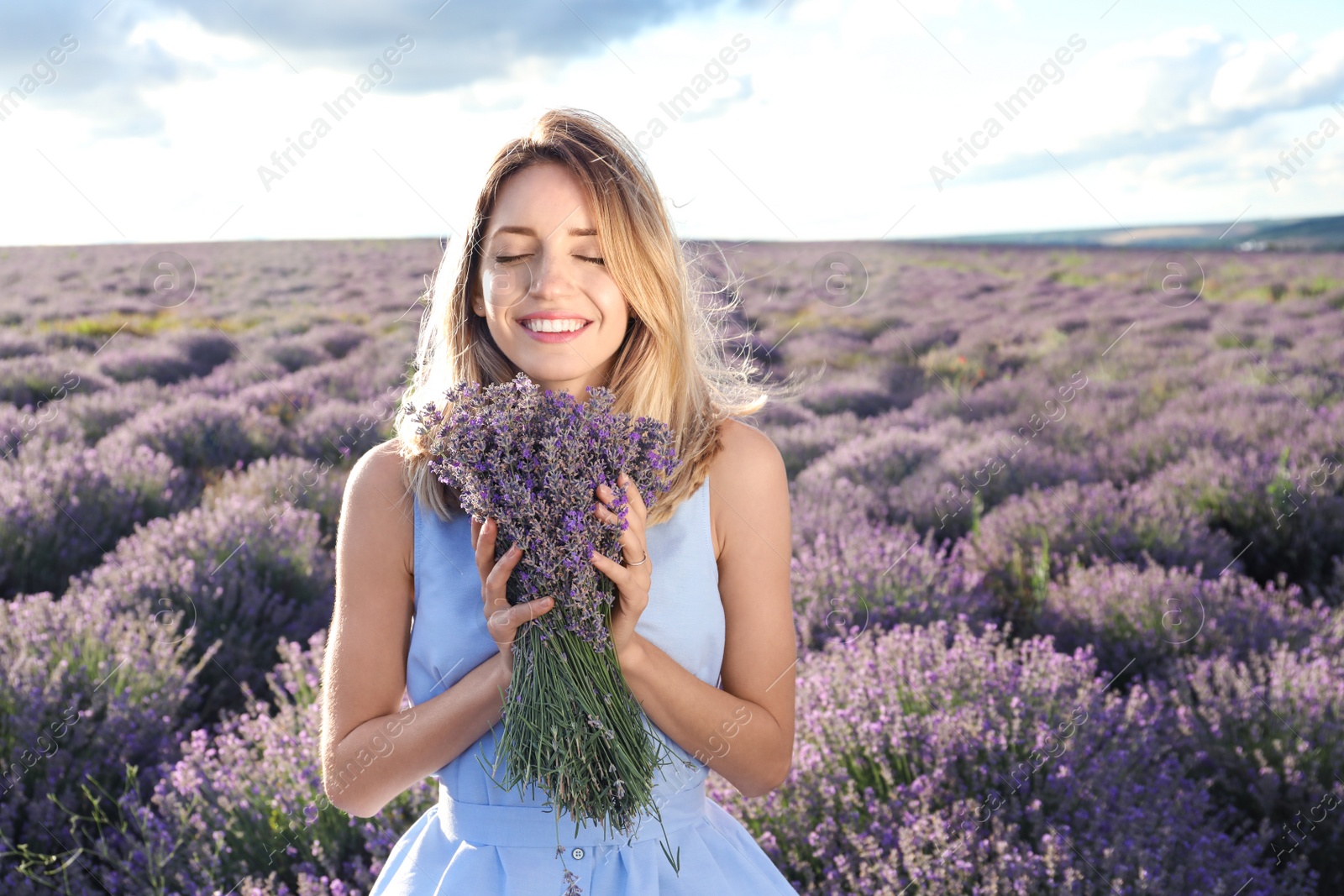 Photo of Young woman with bouquet in lavender field