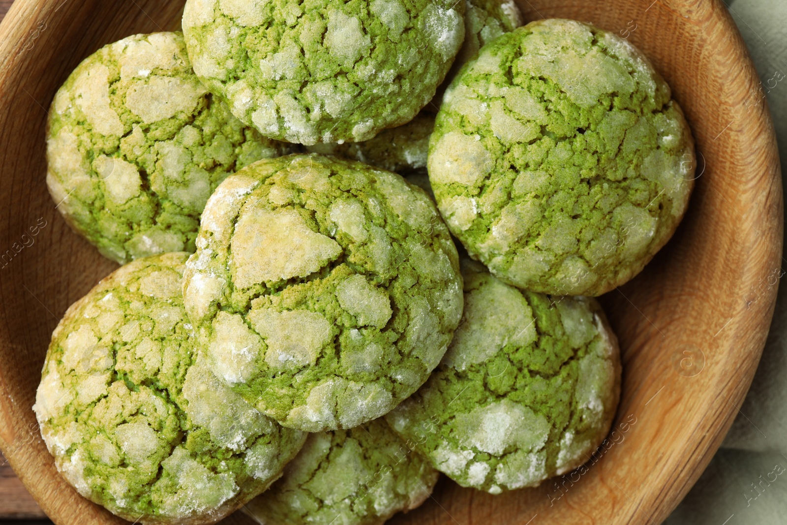 Photo of Bowl with tasty matcha cookies, top view