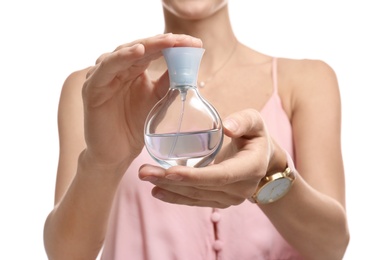 Young woman with perfume bottle on white background, closeup