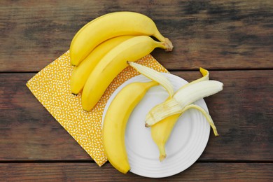 Many delicious ripe bananas on wooden table, flat lay