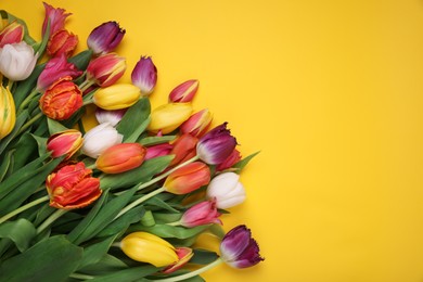 Photo of Beautiful colorful tulip flowers on yellow background, flat lay. Space for text