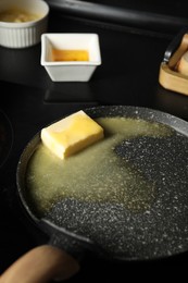 Photo of Melting butter in frying pan on cooktop