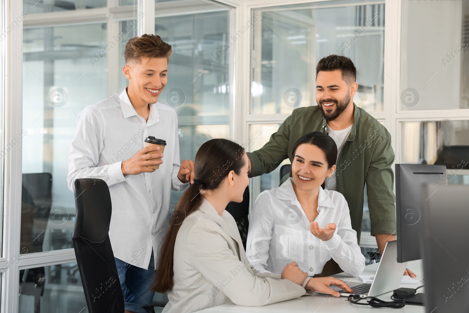 Photo of Colleagues working together in open plan office