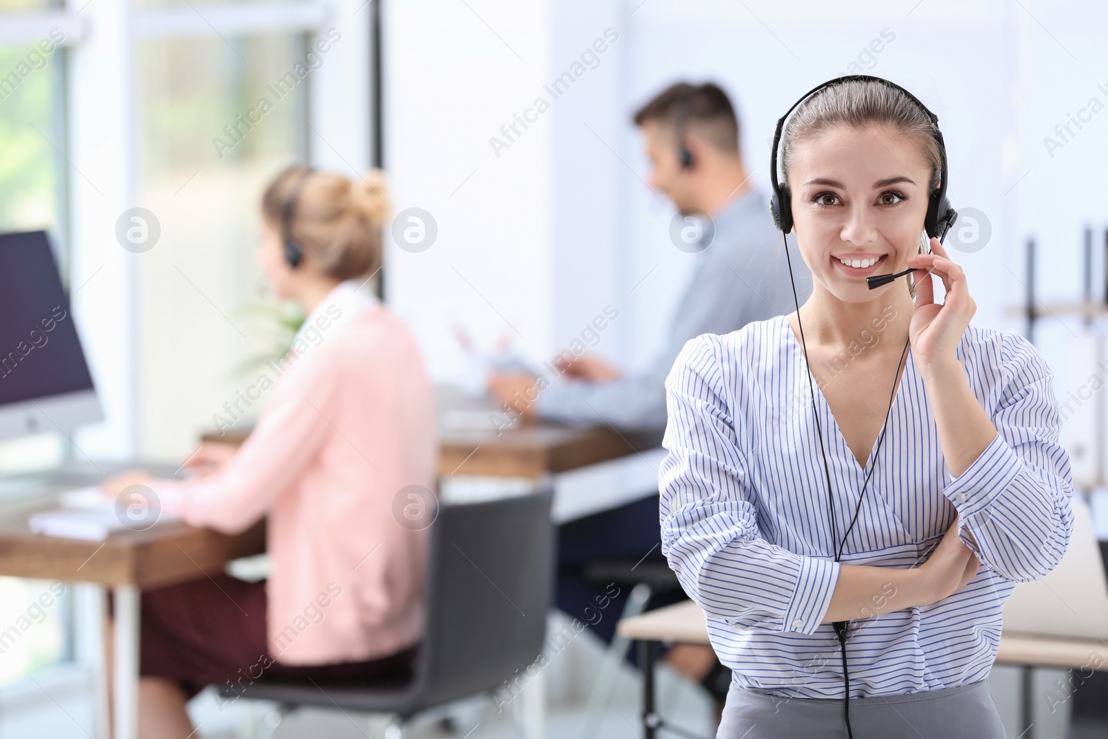 Photo of Young female receptionist with headset in office