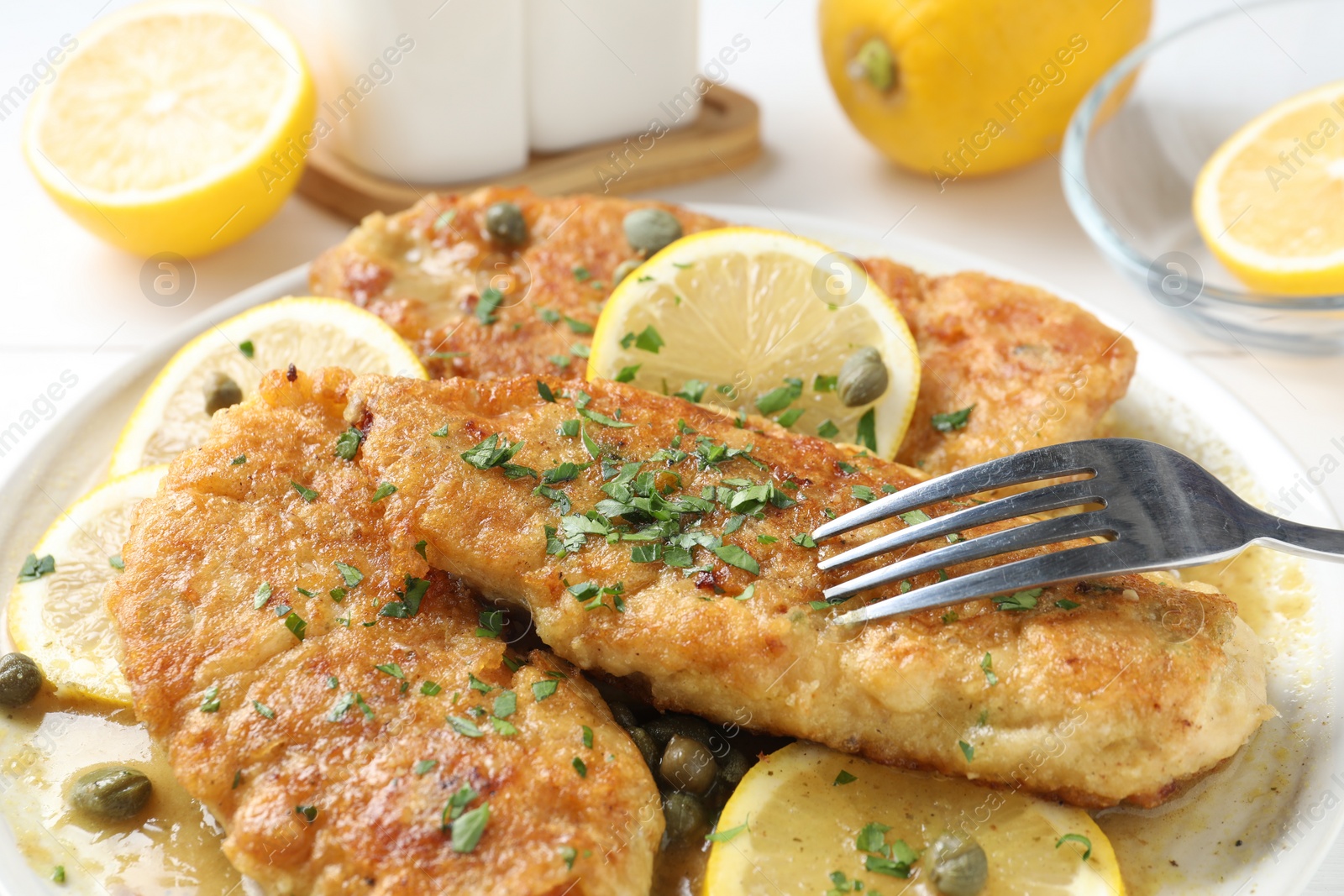 Photo of Delicious chicken piccata served on white table, closeup