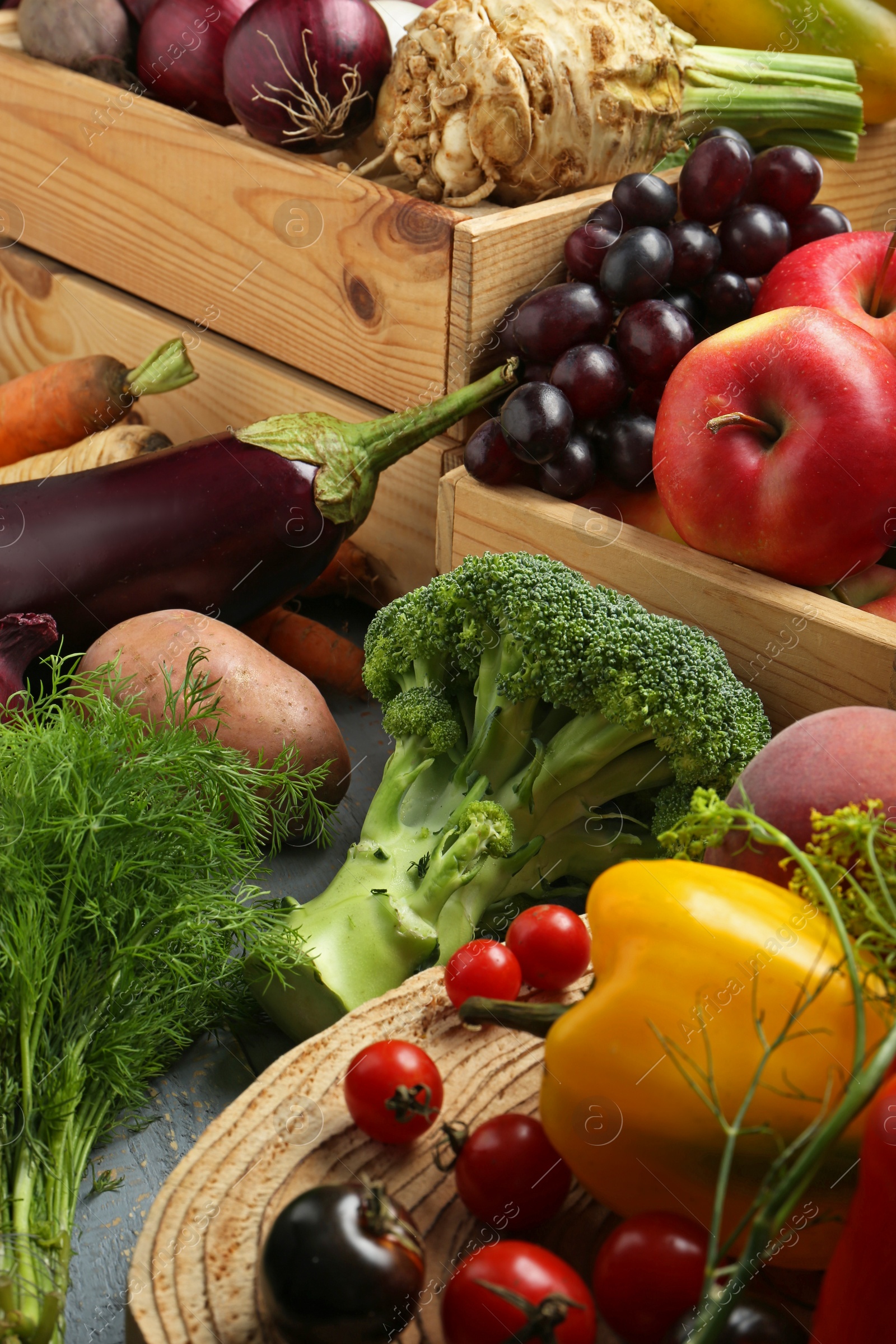 Photo of Different fresh vegetables and fruits on grey wooden table, closeup. Farmer harvesting
