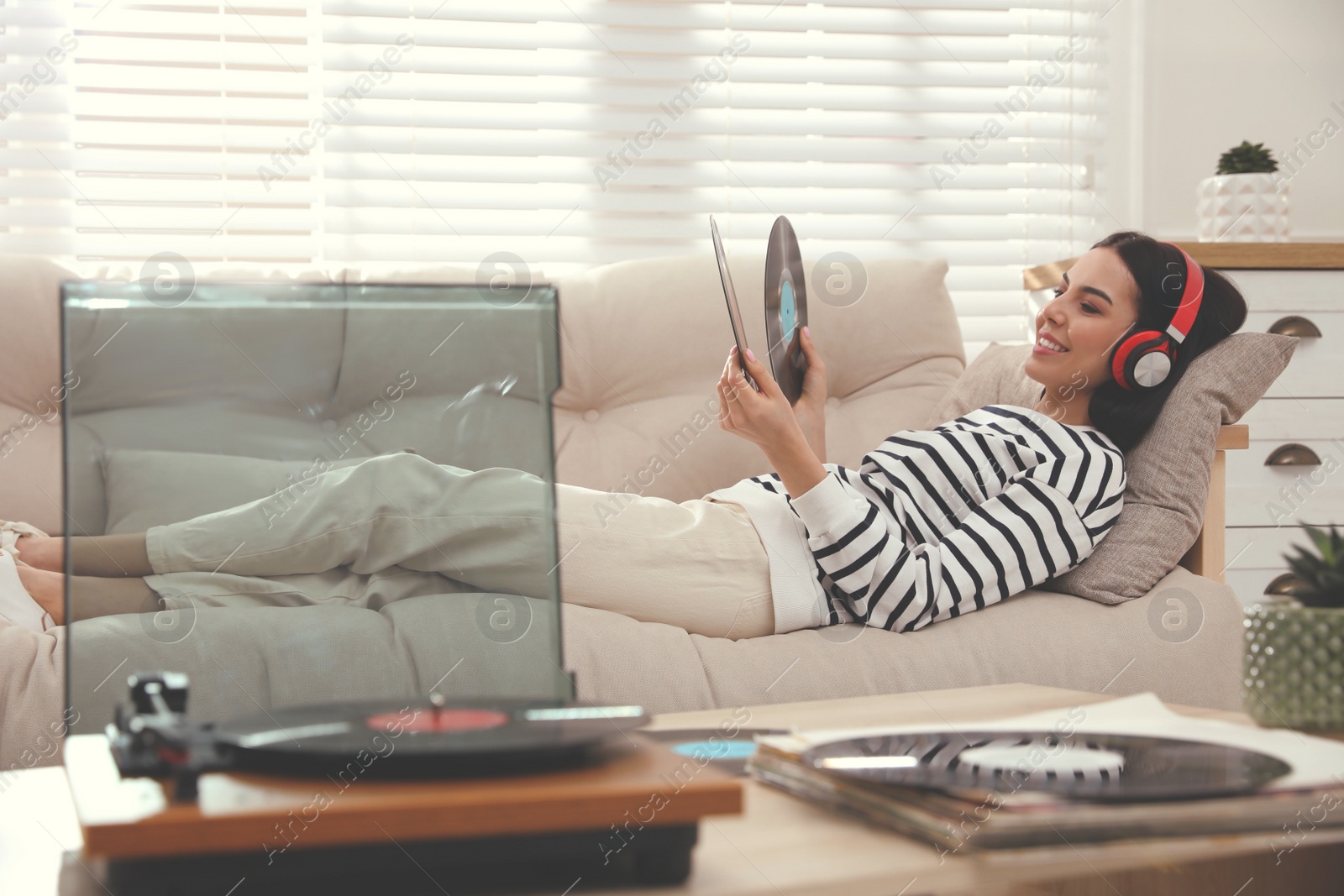 Photo of Woman listening to music with turntable in living room