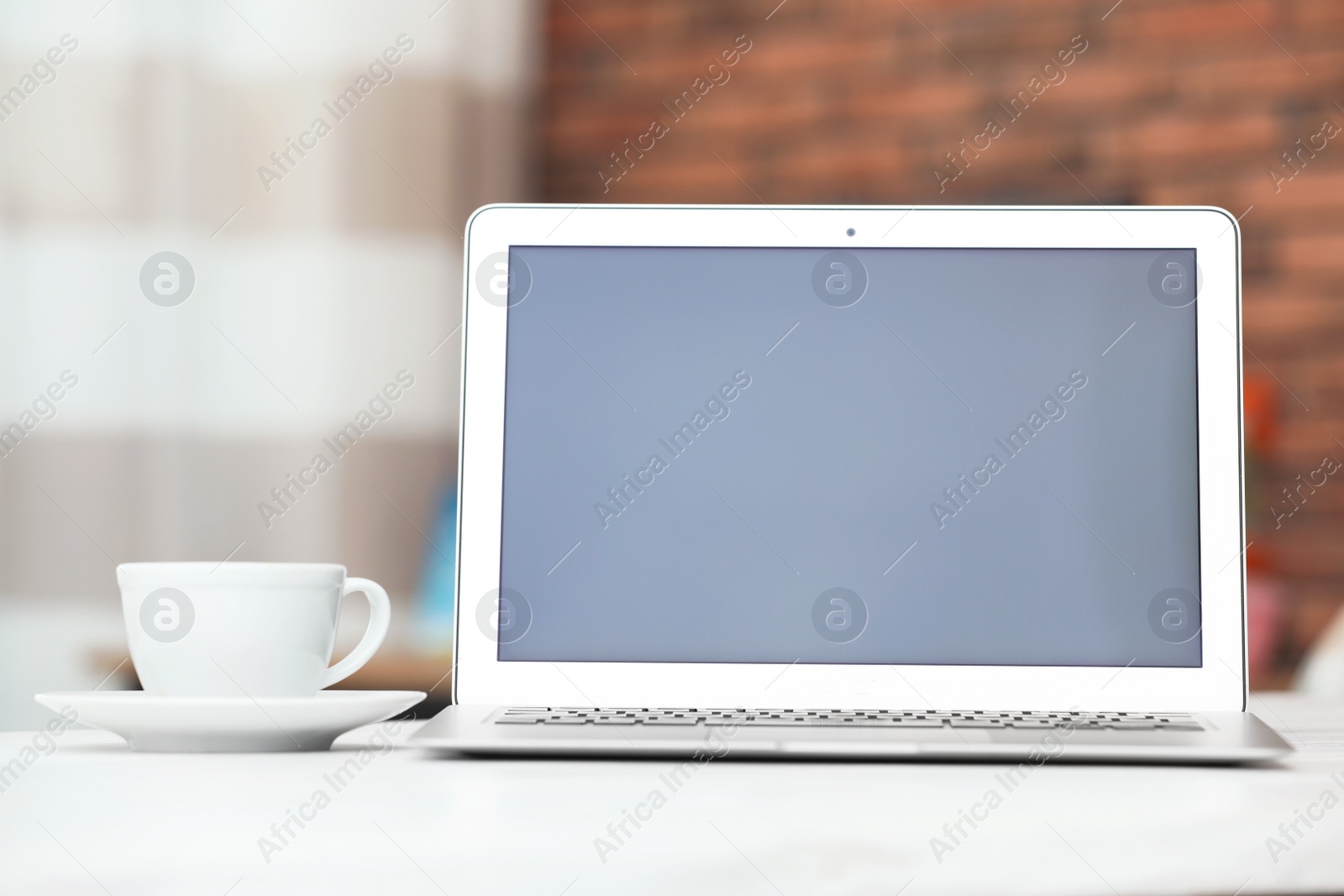 Photo of Laptop with blank screen on table indoors. Space for text