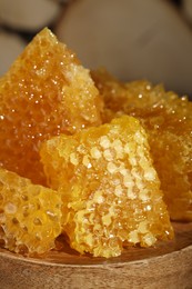 Photo of Natural honeycombs on wooden board, closeup view