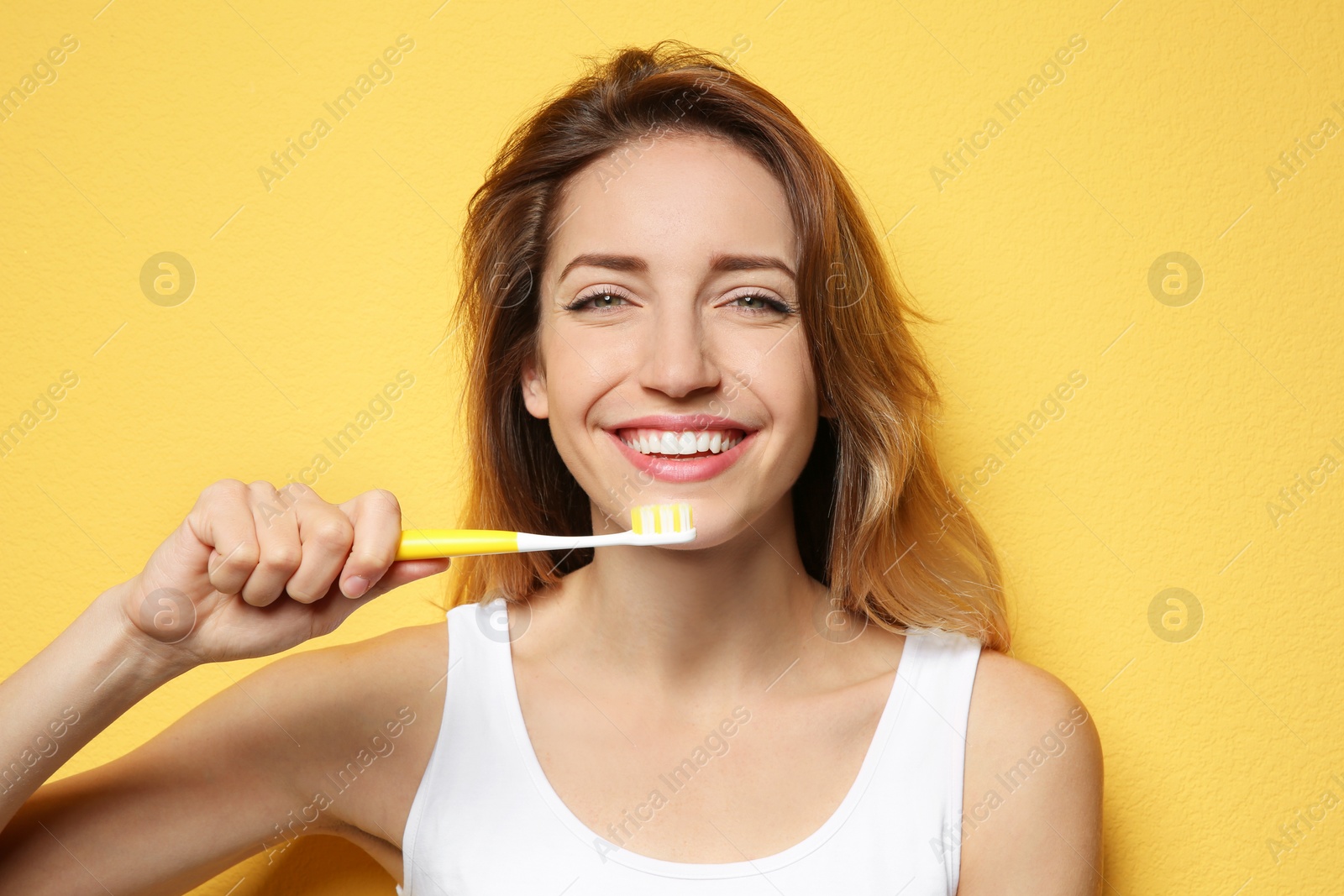 Photo of Portrait of young woman with toothbrush on color background